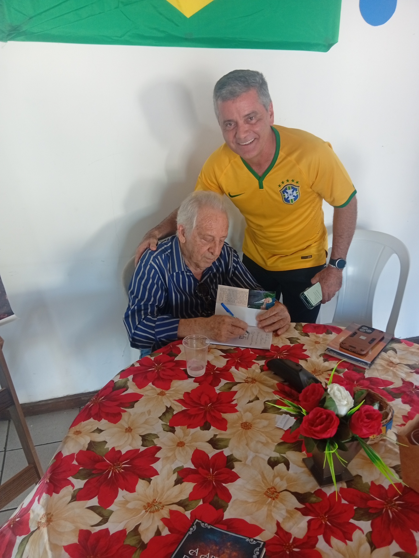 Nilo Belotto autografa exemplar para leitor durante o evento.